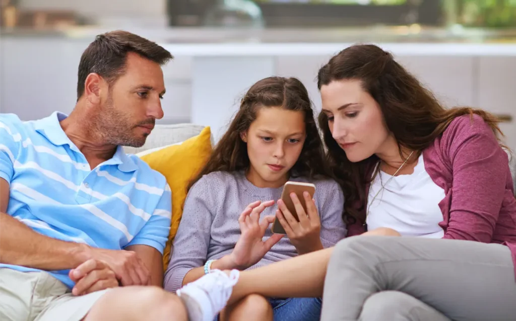 Family sharing a smartphone, focused on the screen