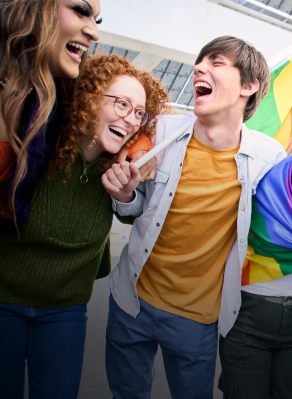 Diverse group laughing with pride flag at a parade